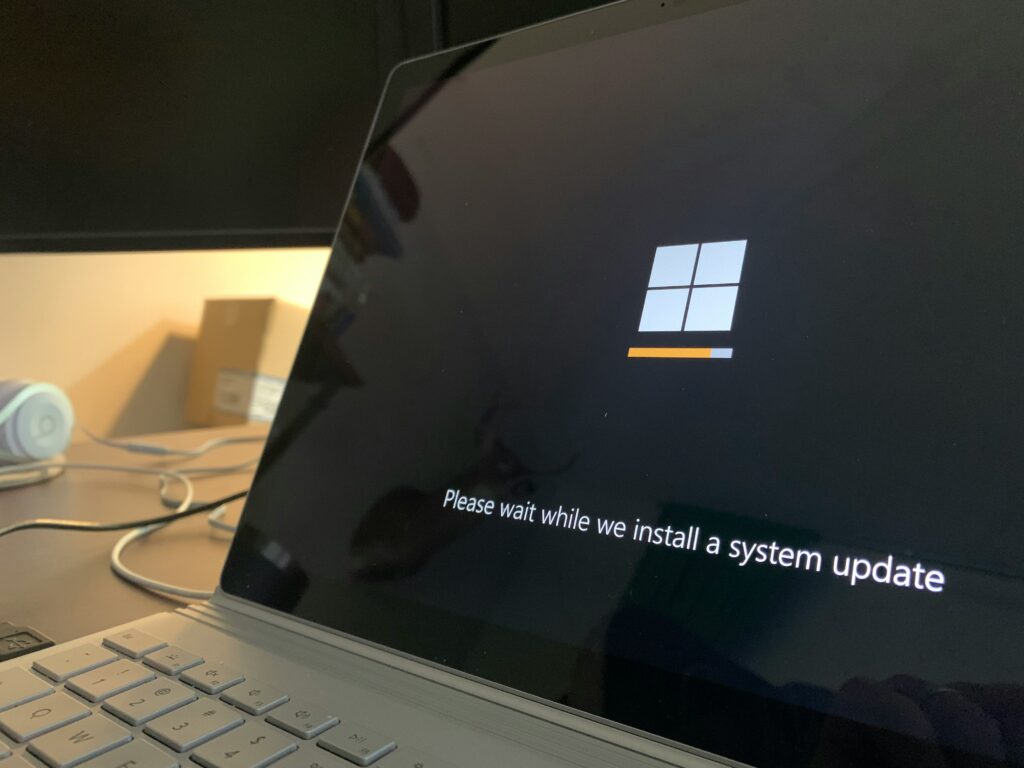 Een Microsoft laptop die een systeemupdate uitvoert, met een voortgangsbalk die de installatie van de update aangeeft.